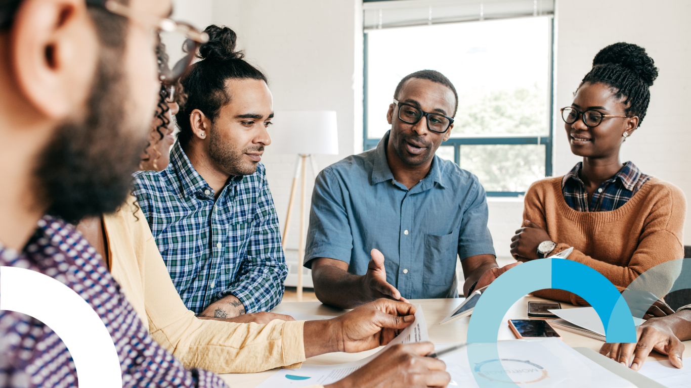 A group of people sit around a table talking to each other about agency pricing models