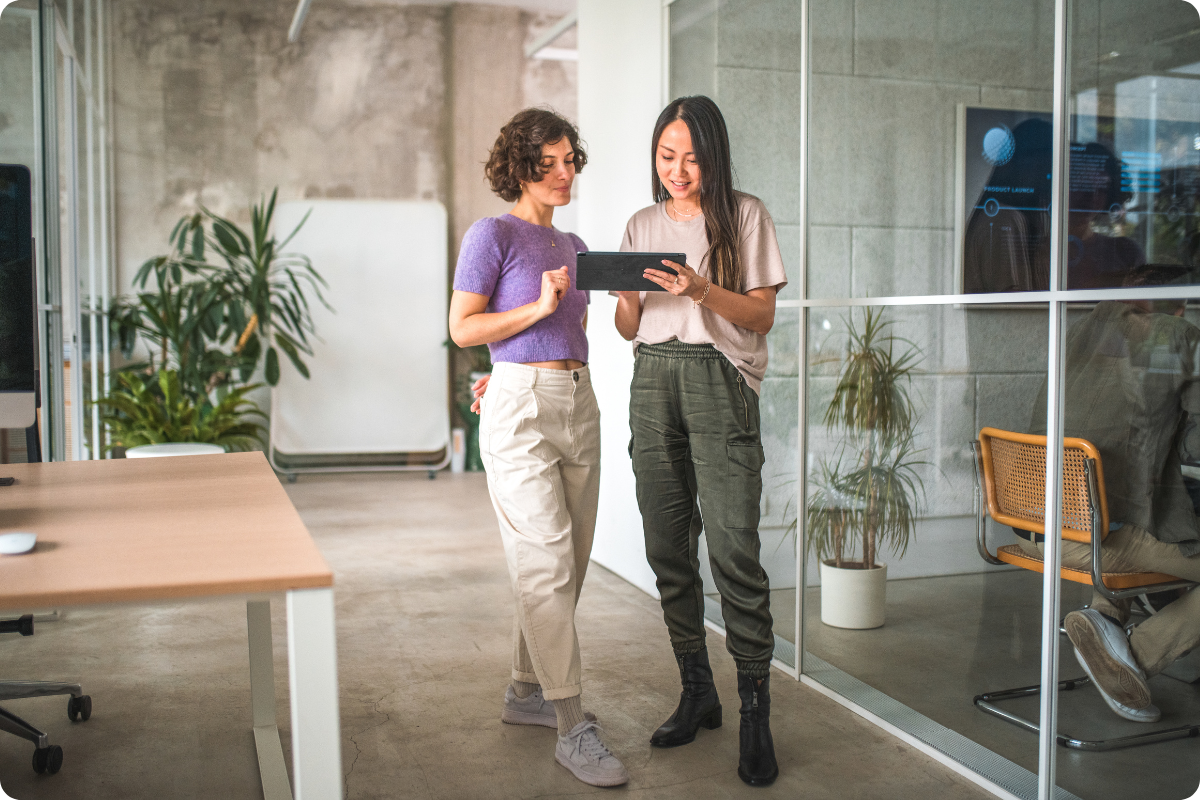 Two women looking at a tablet in an office