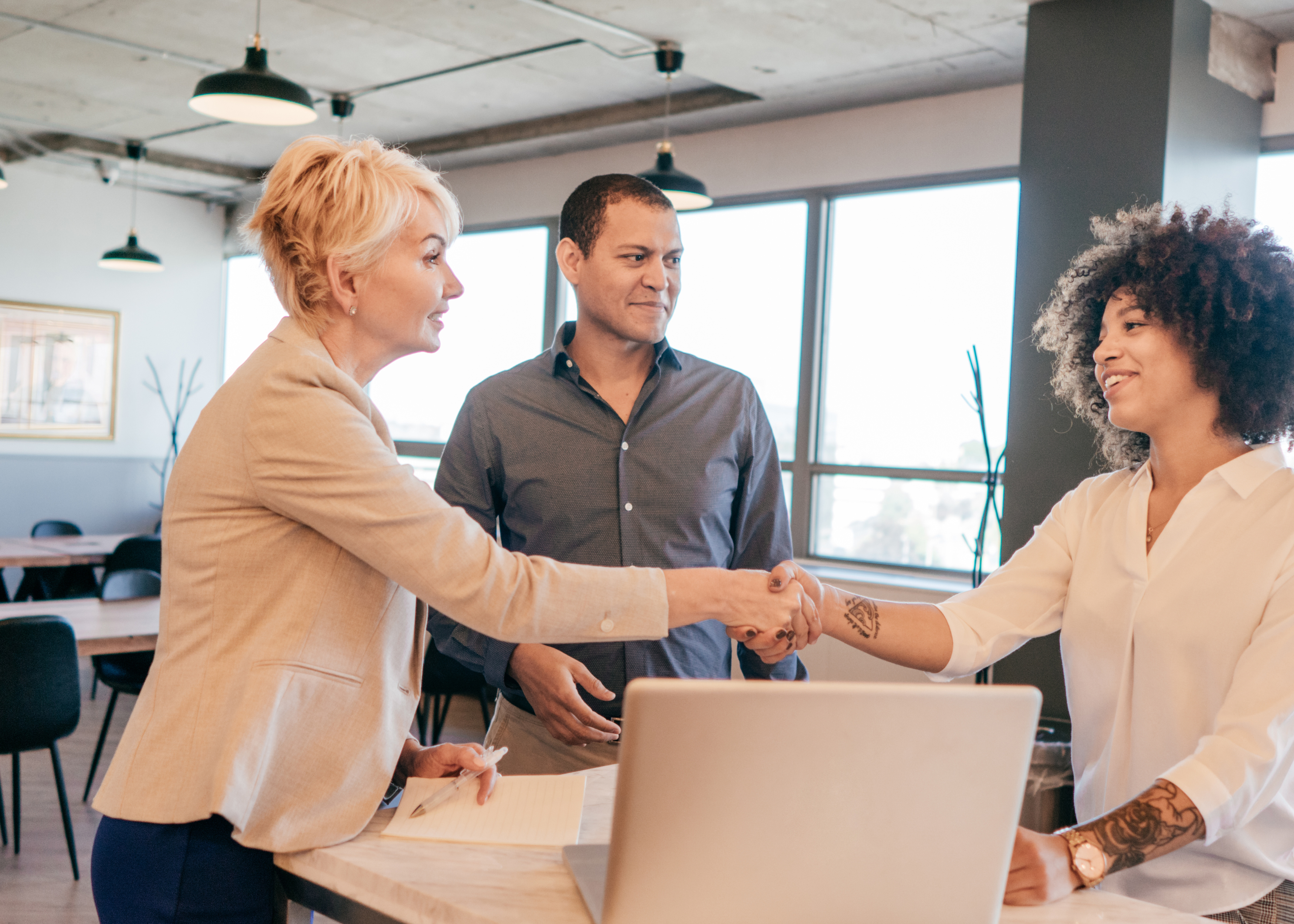 Two businesswomen shaking hands in an office